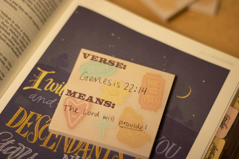 May include: A pink and yellow sticky note with the text "VERSE: Genesis 22:14 MEANS: The Lord will provide!"  The note has a heart, a cross, and a star design.