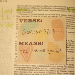 May include: A close-up of a page from a Bible with the text "The Lord Will Provide" highlighted in green. The verse "Genesis 22:14" is written in black marker on a yellow background with a heart shape and the words "The Lord will provide!" written in black marker.