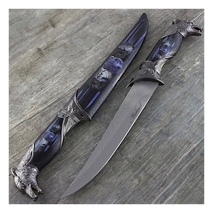 May include: A black and silver knife with a wolf head handle and a blue and silver sheath. The blade is engraved with the name "Michael".
