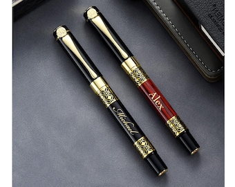 May include: Two personalized pens with gold accents and black and red finishes. The pen on the left has the name "Michael" engraved on it, and the pen on the right has the name "Alex" engraved on it.