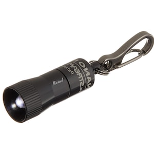 May include: A black keychain flashlight with a silver carabiner clip. The flashlight has the text "Streamlight®" and "OMA" on it. The flashlight also has the word "Michael" engraved on it.