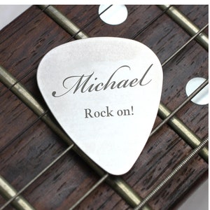 May include: A silver guitar pick with the name "Michael" and the text "Rock on!" engraved on it.