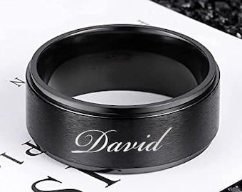 May include: A black ring with the name "David" engraved on it.