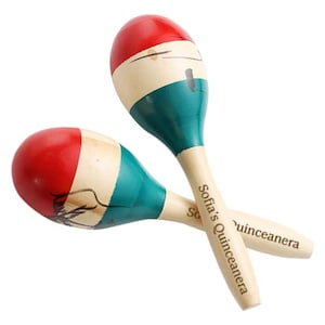 May include: A pair of wooden maracas with red, white and green paint. The maracas are decorated with a black and white design and the text "Sofia's Quinceanera".