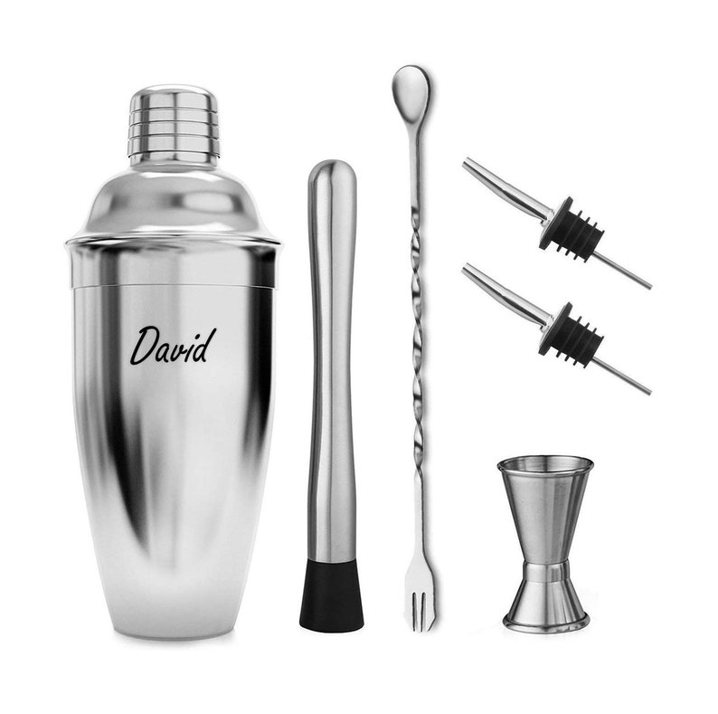 Op de afbeelding: Een cocktail shaker set van roestvrij staal met een gepersonaliseerde inscriptie "David" op de shaker. De set bevat een cocktail shaker, een barlepel, een muddler, een jigger en twee giettuiten.