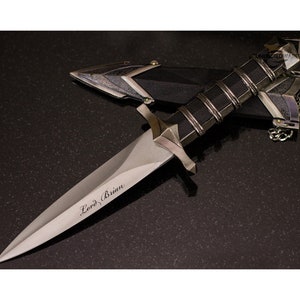 May include: A silver dagger with a black handle and a sheath. The blade is engraved with the words "Lord Brian".
