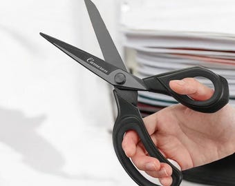 May include: Black scissors with a black plastic handle and a silver blade. The scissors have the word "Camelion" printed on the blade.