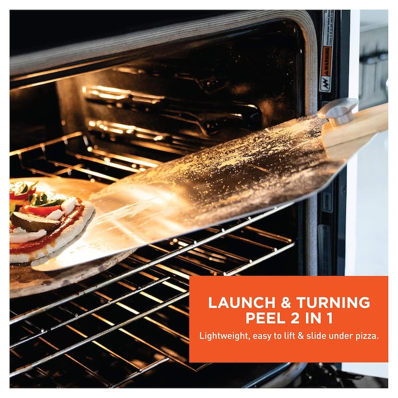 May include: A pizza peel being used to remove a pizza from an oven. The peel is made of metal and wood. The text on the image says "LAUNCH & TURNING PEEL 2 IN 1". The pizza has tomato sauce, cheese, and vegetables.