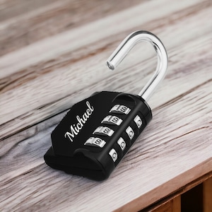 May include: Black combination padlock with a silver hook and the name "Michael" engraved on the side. The padlock has a four-digit combination lock.