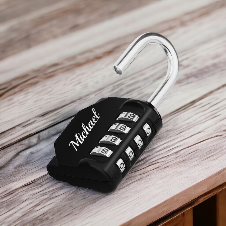 May include: Black combination padlock with a silver hook and the name "Michael" engraved on the side. The padlock has a four-digit combination lock.