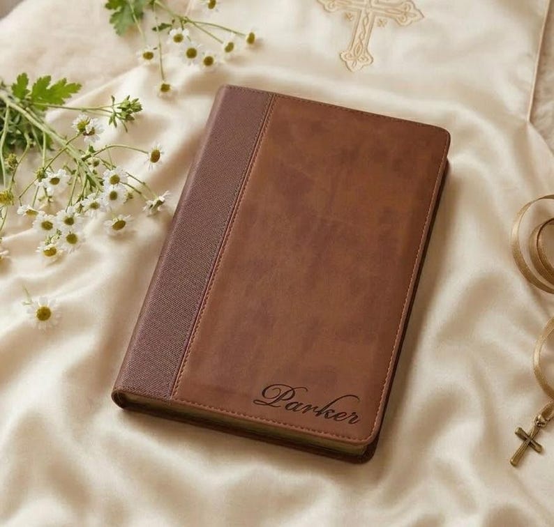 Op de afbeelding: Een rechthoekig bruin notitieboek met een gestructureerde rug en een gladde voorkant waarop de naam Parker in cursief schrift is gegraveerd. De kaft heeft een tweekleurige bruine afwerking met een verticale naad tussen de delen.
