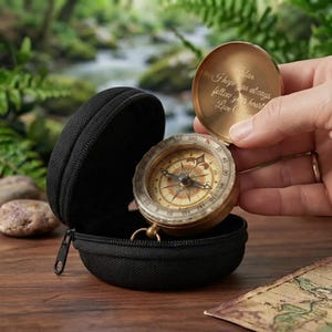 Puede incluir: Una brújula de bolsillo de latón con una tapa abatible que tiene grabado en el interior 'Aidan I hope you always follow your heart Love Mom'. La brújula cuenta con una esfera circular con puntos cardinales y un estuche negro con cremallera.