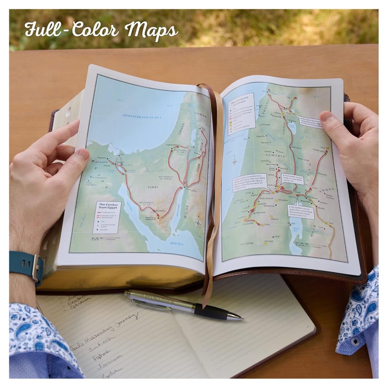 May include: An open book with a full-colour map of the Exodus from Egypt and a map of the Holy Land. The book has a brown leather cover and gold-toned edges. The text on the map includes place names such as "The Exodus from Egypt", "Sinai", "Galilee", and "Samaria".