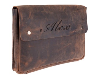 Può includere: Una pochette in pelle marrone con chiusura a lembo e un rivetto argentato su ogni lato. Il nome "Alex" è inciso sul lembo anteriore.