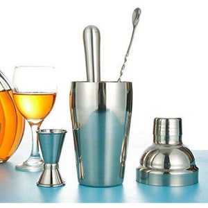 Op de afbeelding: Een set van roestvrijstalen cocktailshaker, jigger en roerstaaf. De shaker heeft een deksel en een ingebouwde muddler. De jigger is een dubbelzijdige maatbeker. De roerstaaf heeft een gedraaide handgreep.