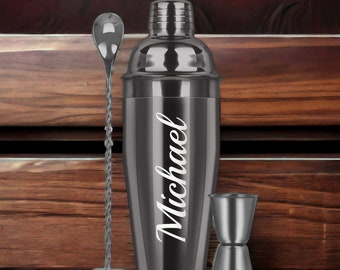 May include: A black cocktail shaker set with a silver bar spoon and jigger. The shaker has the name "Michael" engraved on it.