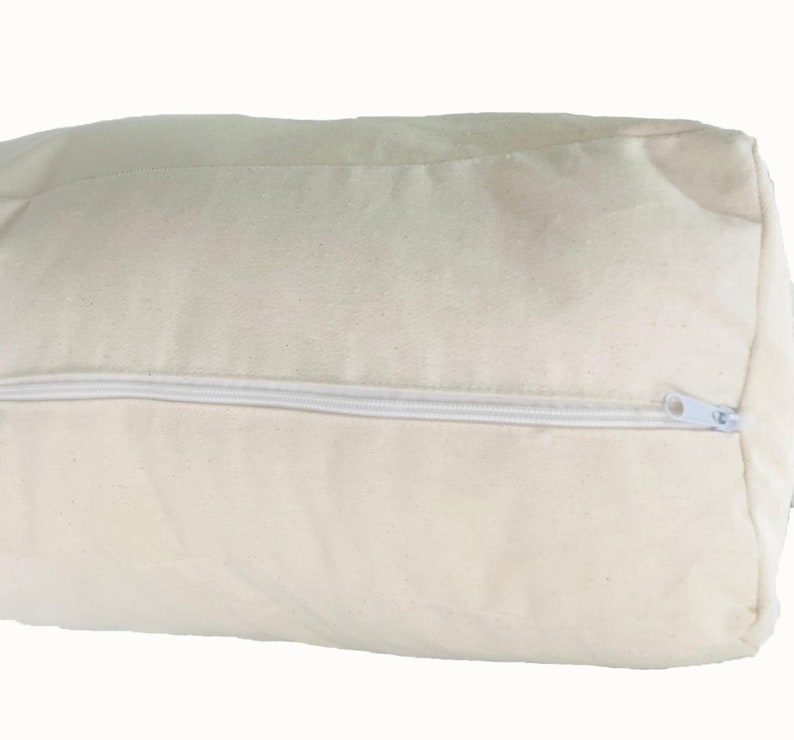May include: A rectangular, off-white pillow with a white zipper closure. The pillow is made of a soft, textured fabric. The zipper runs along one side of the pillow, allowing for easy removal of the pillow's contents.
