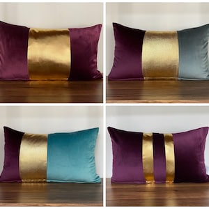 May include: Four decorative throw pillows with a velvet fabric exterior. The pillows are in a variety of colours, including teal, burgundy, and gold. The pillows have a contrasting stripe of gold fabric down the centre.