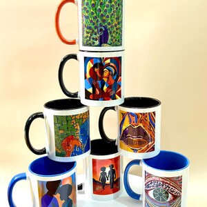 May include: A collection of white ceramic mugs with diverse, vibrant designs. The mugs display images of a peacock, abstract art, and human silhouettes. Some mugs have coloured handles and interiors.