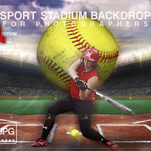 May include: A digital backdrop featuring a softball player in a red jersey and black pants, swinging a bat. The player is positioned in front of a large yellow softball with red stitching. The background shows a baseball stadium with a green field, a brown dirt infield, and a large crowd of spectators in the stands.