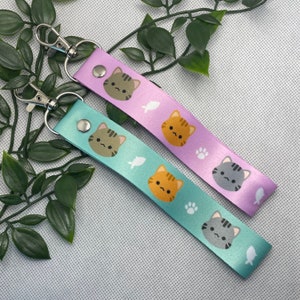 Correa para llaves de muñeca, cordón y porta pases en forma de gato atigrado. Lindo regalo kawaii para amantes de los gatos y dueños de gatos. Deadlybearhug