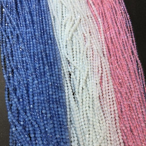 Könnte beinhalten: Drei Stränge facettierter Glasperlen. Die Perlen sind in Blautönen, Weiß und Rosa.