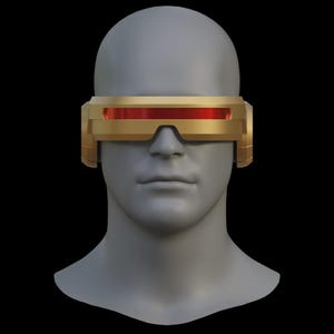 May include: A gold-colored visor with a red lens, resting on a gray mannequin head. The visor has a rectangular shape with a horizontal red lens and side pieces. The background is black.