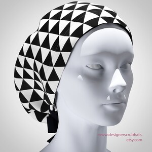 May include: Black and white geometric patterned surgical scrub hat. The hat has a triangular pattern.