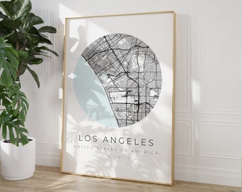 May include: A black and white map of Los Angeles, California, in a circular design with a light blue background. The text "Los Angeles, United States of America, 34.1° N, 118.2° W" is printed below the map.