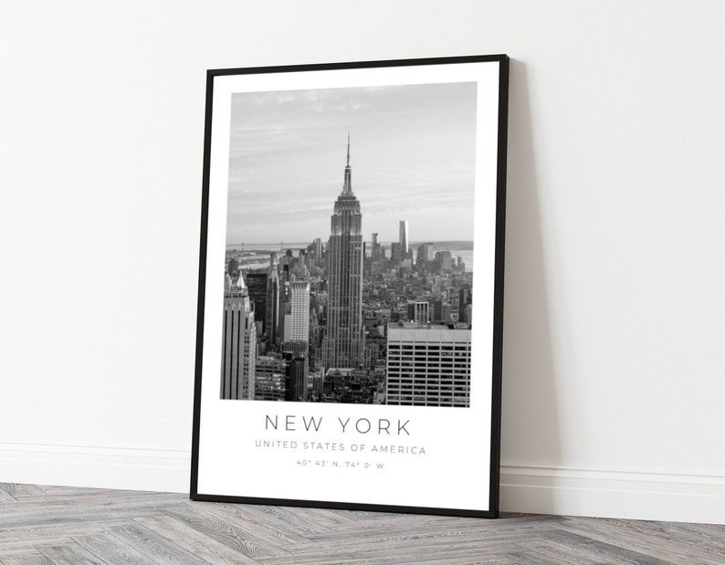 May include: Black and white photograph of the New York City skyline, featuring the Empire State Building. The text "NEW YORK", "UNITED STATES OF AMERICA", and "40&deg; 47' N, 74&deg; 0' W" is printed below the image.