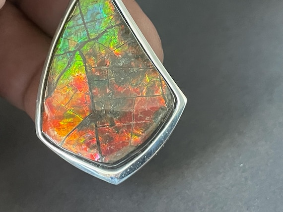 A slightly larger, very beautiful, and rare ammolite design pendant made of 925 sterling silver. (Ammolite ranges from fiery red to orange-green....)
