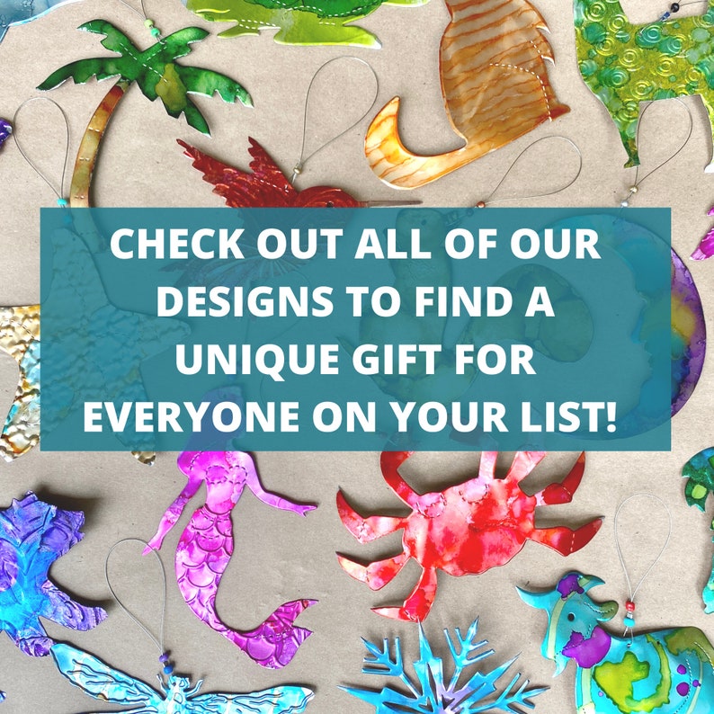 May include: A collection of colorful metal ornaments featuring various designs, including a palm tree, a hummingbird, a mermaid, a crab, a snowflake, and a cow. The ornaments are hanging from strings and are arranged on a brown surface. The text "CHECK OUT ALL OF OUR DESIGNS TO FIND A UNIQUE GIFT FOR EVERYONE ON YOUR LIST!" is displayed in a blue box.