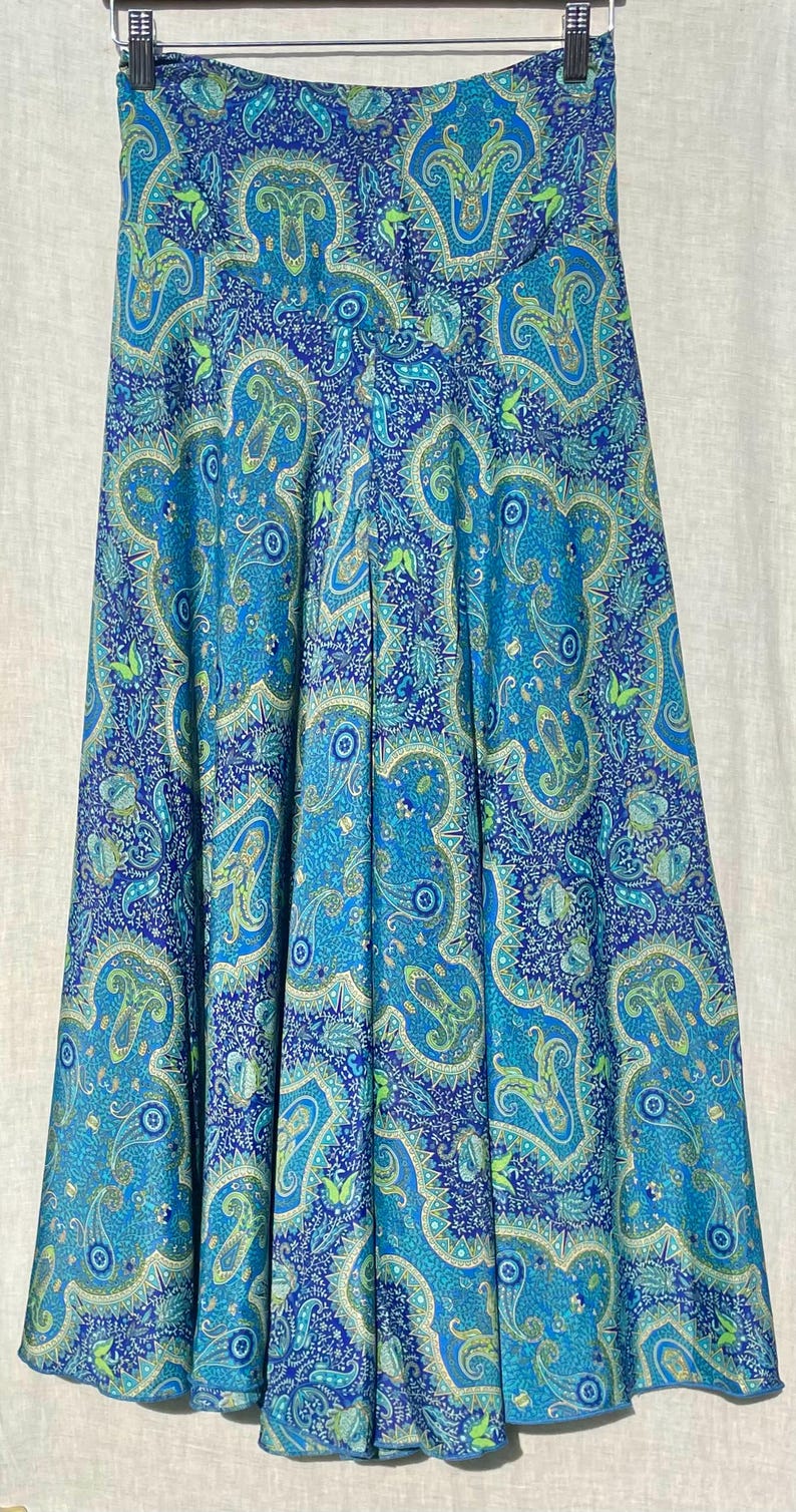 May include: A blue and green paisley patterned skirt with a high waist and a flowing silhouette.