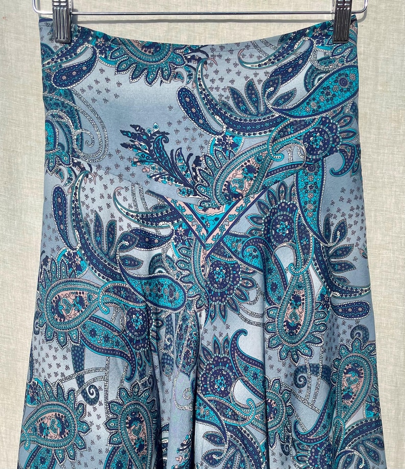 May include: A blue and white paisley print skirt with a high waist. The skirt is made of a soft, flowing fabric.