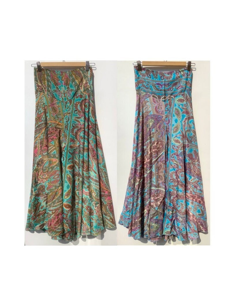 May include: A strapless maxi skirt with a paisley print in shades of teal, pink, brown, and gold. The skirt has a gathered waist and a flowing silhouette.