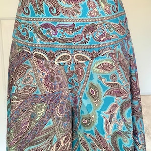 May include: A blue skirt with a paisley pattern. The skirt has a waistband and a flowing silhouette.