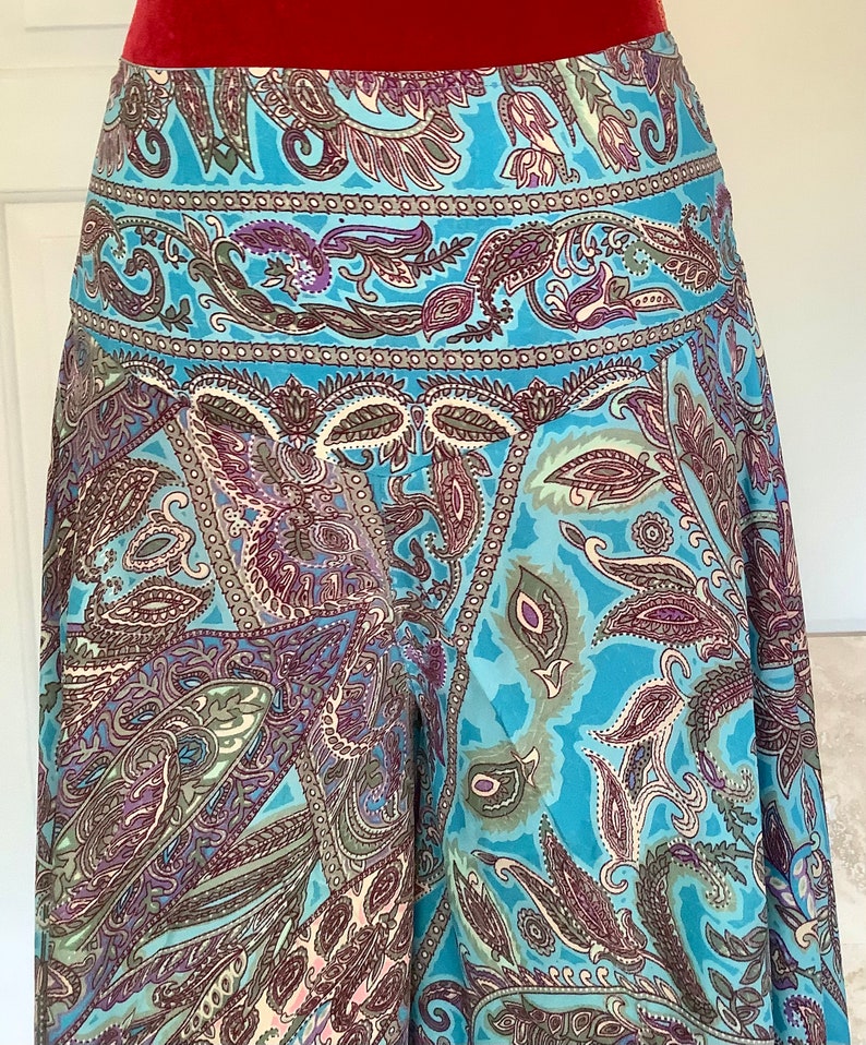 May include: A blue skirt with a paisley pattern. The skirt has a waistband and a flowing silhouette.
