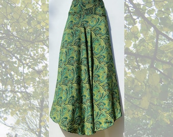 May include: A long green skirt with a paisley pattern. The skirt has a high waist and a flowing, A-line silhouette.