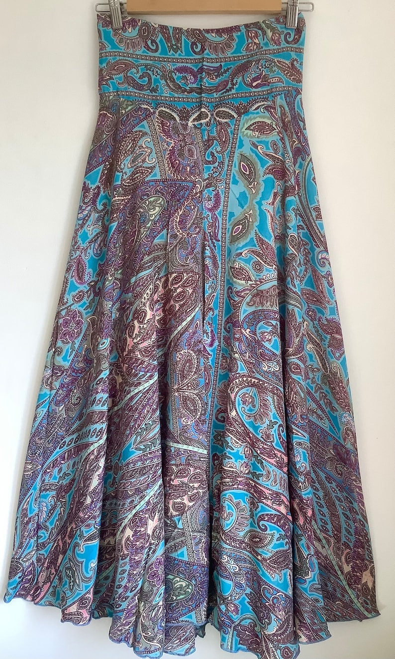 May include: A blue and purple paisley patterned skirt with a flared silhouette.