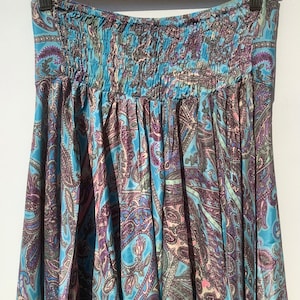 May include: A blue and purple paisley patterned skirt with an elastic waistband.