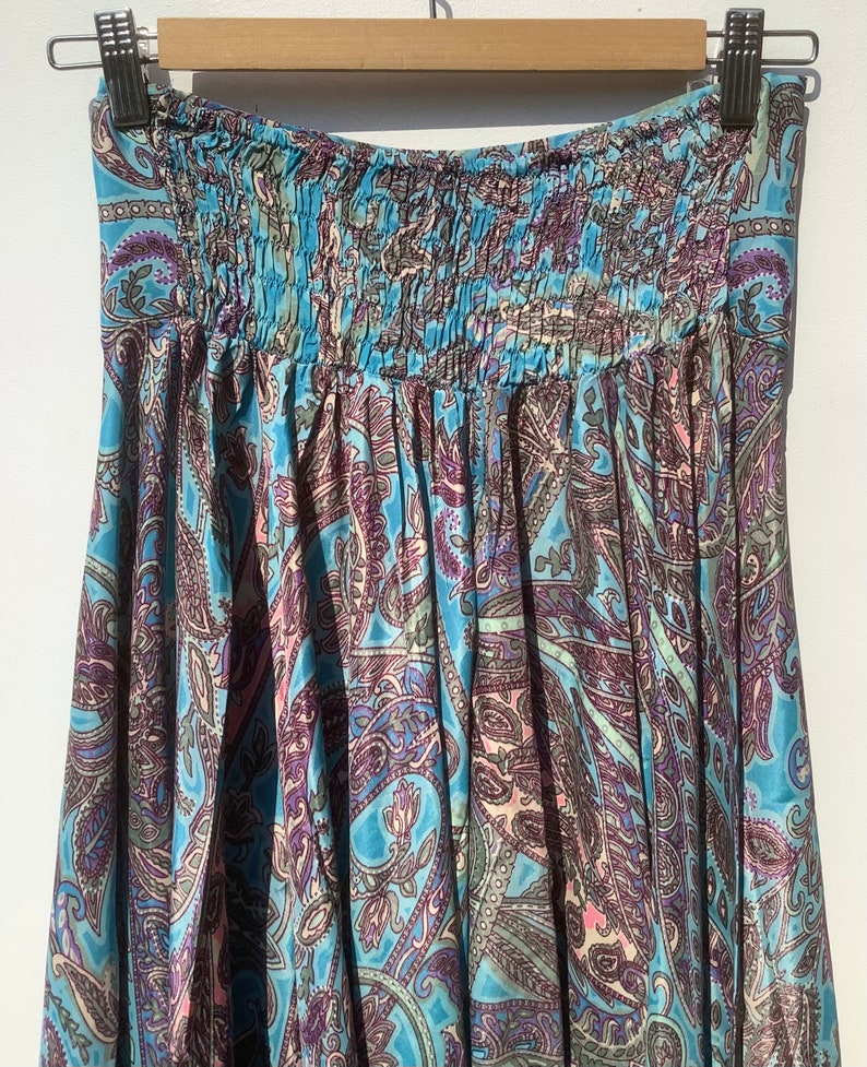 May include: A blue and purple paisley patterned skirt with an elastic waistband.