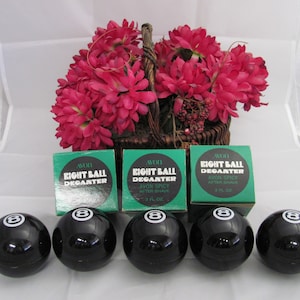 May include: Five black and white eight ball aftershave bottles with green and white labels that say "Eight Ball Deganter Avon Spicy After Shave 3 fl oz".