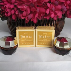May include: Two small, gold and brown glass perfume bottles with red tops. The bottles are labeled "Avon Timeless Ultra Creme Perfume" and have a net weight of 0.66 oz.