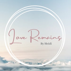 Puede incluir: Un c&iacute;rculo blanco con un doble contorno sobre un fondo de cielo nublado. El texto "Love Remains" en letra cursiva rosa est&aacute; centrado en el c&iacute;rculo. El texto "By Heidi" est&aacute; centrado debajo del c&iacute;rculo.