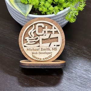 May include: A wooden award plaque with a stylized image of a computer monitor, a coffee cup, and the text "C++". The plaque also includes the text "Michael Smith, MS Web Developer" and a laurel wreath.