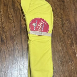 May include: Bright yellow tabi socks, a traditional Japanese split-toe sock. The socks are folded and secured with a white band, featuring a circular label with Japanese text and the brand name "Tabeez". Size 11 1/2 is visible on the label.