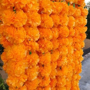 Puede incluir: Una guirnalda de flores de cal&eacute;ndula de color naranja brillante, perfecta para agregar un toque festivo a cualquier ocasi&oacute;n.