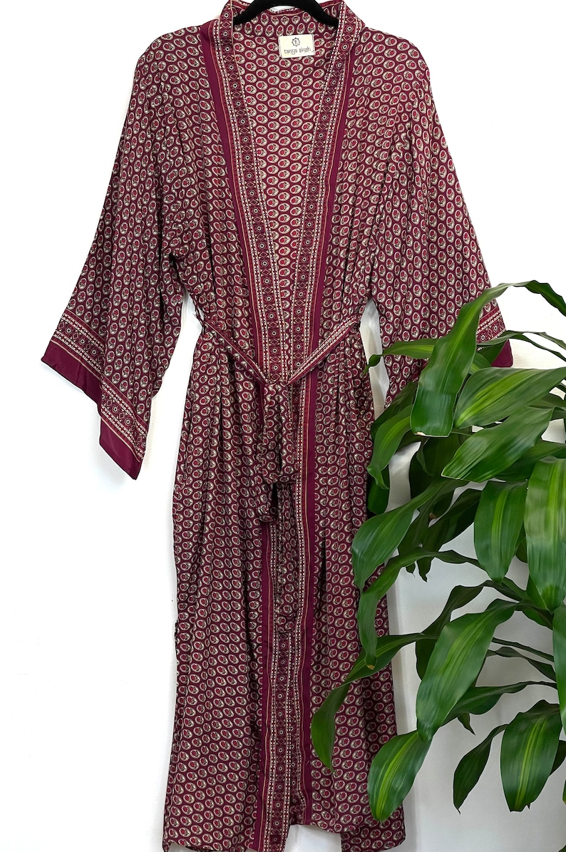 May include: A long, burgundy robe with a paisley pattern and a matching sash. The robe has a  "Temple of Style" label.