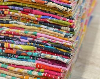 May include: A stack of colorful fabric squares, each with a different pattern, are neatly folded and stacked on top of each other. The fabric is a mix of cotton and silk, and the colors are bright and vibrant. The fabric is hand-stitched and has a unique, rustic look.