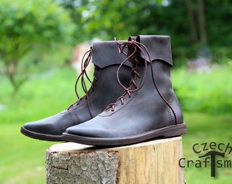 May include: A pair of brown leather boots with laces, sitting on a tree stump. The boots have a pointed toe and a slightly raised heel.